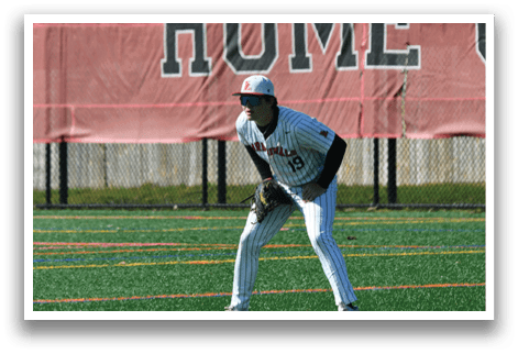 A baseball player in a white and black uniform is standing on a field. Description generated by AI