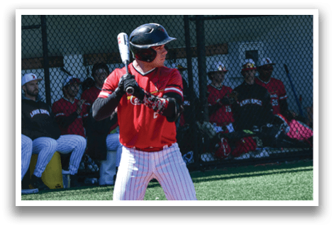 A baseball player in a red and white uniform is holding a bat and waiting for the pitch. Description generated by AI