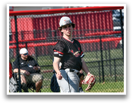 A baseball player wearing a black and red shirt and a hat. Description generated by AI