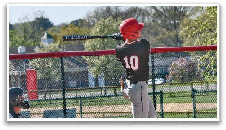 A boy is swinging a baseball bat. Description generated by AI