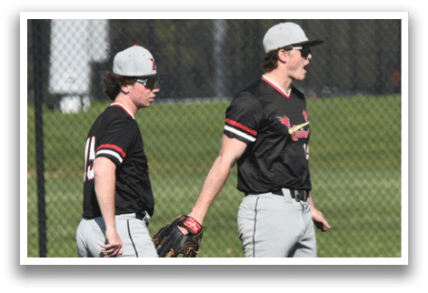Two baseball players standing on a field. Description generated by AI