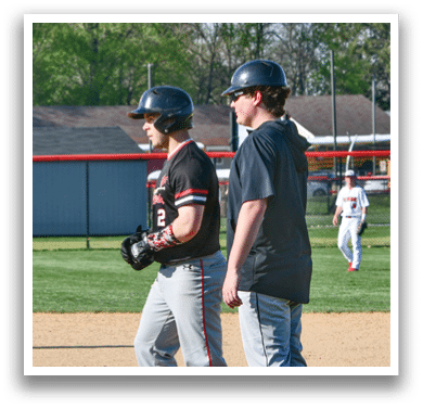 Two baseball players standing on the field. Description generated by AI