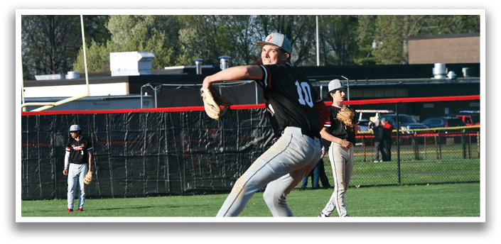 A baseball player in a black shirt and grey pants is throwing a ball. Description generated by AI