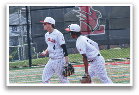 A baseball field with a fence and two baseball players. Description generated by AI