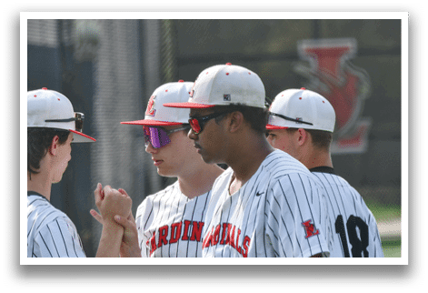A group of baseball players wearing red and black uniforms. Description generated by AI