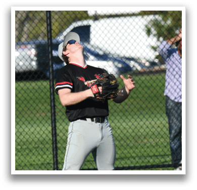 A baseball player catching a ball. Description generated by AI