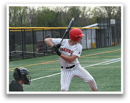 A baseball player in a red helmet and white uniform is swinging a bat. Description generated by AI