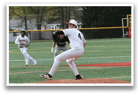 A baseball player in a white and black uniform is pitching a ball. Description generated by AI