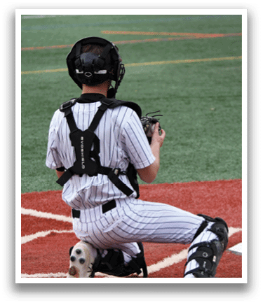 A baseball player wearing a helmet and kneeling on the field. Description generated by AI