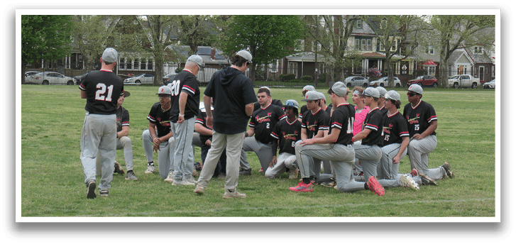 A group of baseball players are sitting on the grass. Description generated by AI