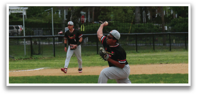A baseball player in a black and red shirt is pitching a ball. Description generated by AI