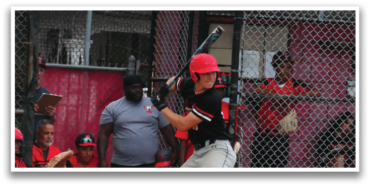 A baseball player in a red helmet and black shirt is swinging a bat. Description generated by AI