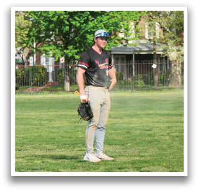 A man wearing a black and red shirt and holding a baseball glove. Description generated by AI