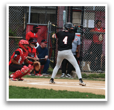 A baseball player in a black shirt and white pants is swinging a bat. Description generated by AI