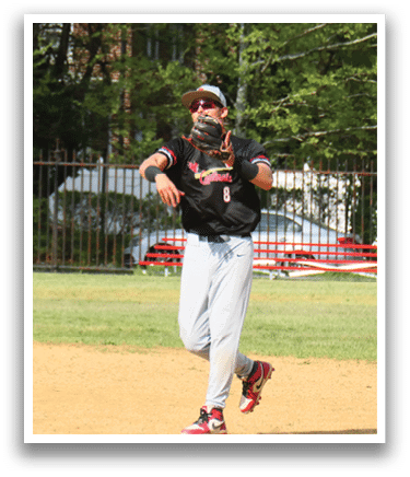 A baseball player in a black shirt and red shoes throwing a ball. Description generated by AI