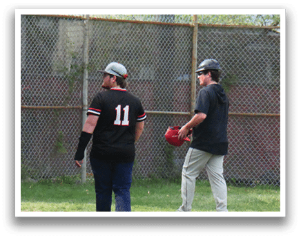 Two men wearing black and red shirts are walking on a baseball field. Description generated by AI