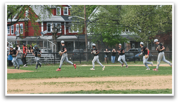 A group of young men playing baseball on a field. Description generated by AI