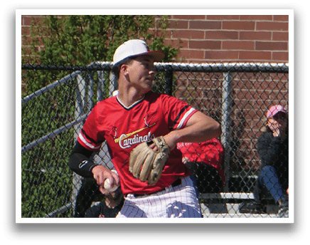 A baseball player in a red shirt and white hat is pitching a ball. Description generated by AI