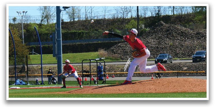 A baseball player in a red shirt and white pants is throwing a ball. Description generated by AI