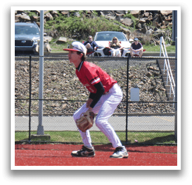 A baseball player in a red and white uniform is standing on the field. Description generated by AI