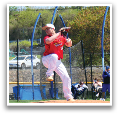 A baseball player in a red shirt and white pants is pitching a ball. Description generated by AI