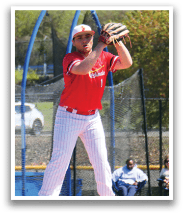 A baseball player in a red shirt and white pants is pitching a ball. Description generated by AI
