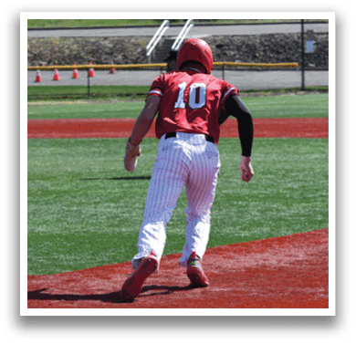 A baseball player wearing a red and white uniform is running on the field. Description generated by AI