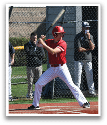 A baseball player in a red shirt and white pants holding a bat. Description generated by AI