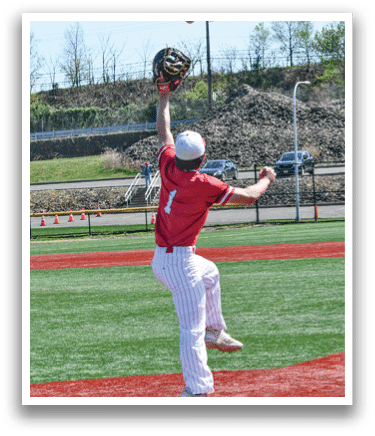 A baseball player in a red shirt and white pants catching a ball. Description generated by AI