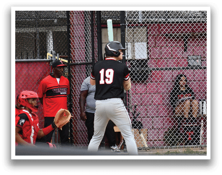 A baseball player is holding a bat and getting ready to hit a ball. Description generated by AI