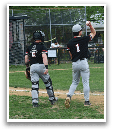 A baseball player wearing a black shirt and hat is holding a baseball bat. Description generated by AI