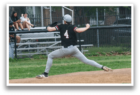 A baseball player in a black shirt and white pants is pitching a ball. Description generated by AI