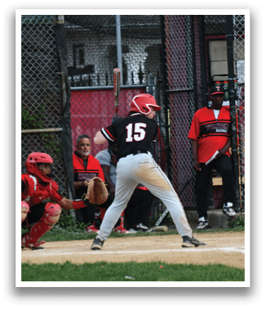 A baseball player is up to bat, wearing a black shirt and red helmet. Description generated by AI