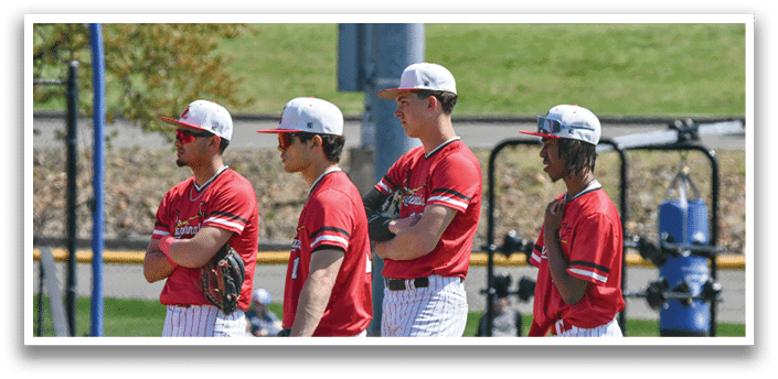 Four baseball players wearing red shirts and white pants. Description generated by AI