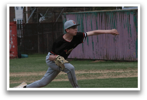 A baseball player in a black and red shirt is pitching a ball. Description generated by AI