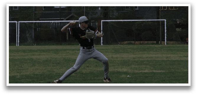A baseball player in a black and red shirt is holding a bat and getting ready to swing. Description generated by AI