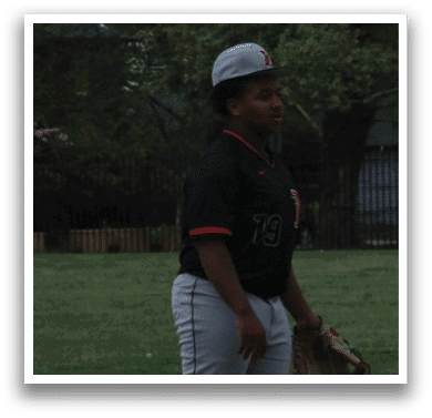 A baseball player wearing a black shirt and hat with the number 12 on it. Description generated by AI