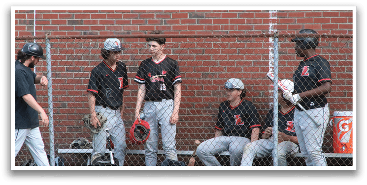 A group of baseball players sitting on a bench. Description generated by AI