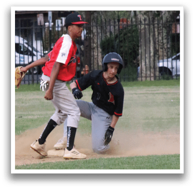 A boy in a red shirt and black pants is running on a baseball field. Description generated by AI