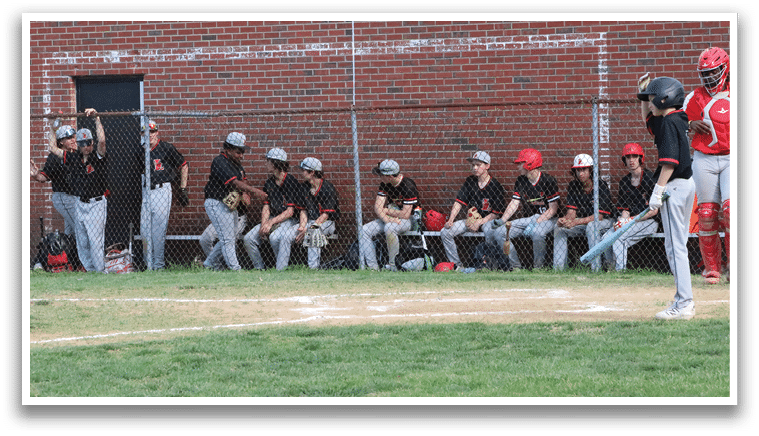 A baseball player is holding a bat and standing in the dirt. Description generated by AI