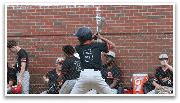 A baseball player is holding a bat and getting ready to swing. Description generated by AI