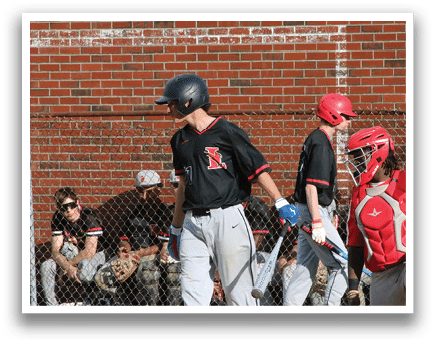A baseball player wearing a black shirt and red hat. Description generated by AI