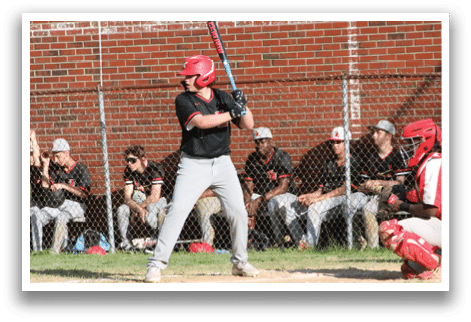 A baseball player holding a bat, ready to hit the ball. Description generated by AI