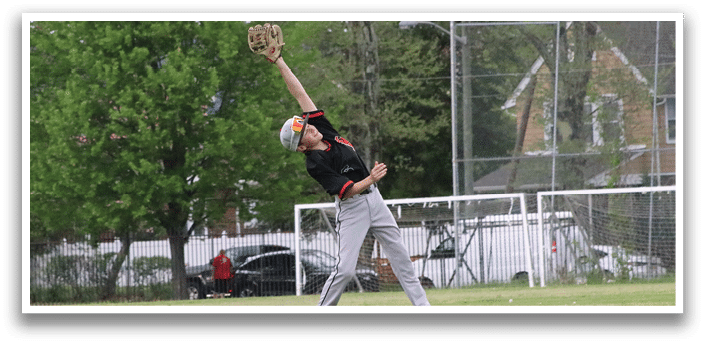 A person wearing a black shirt and white shoes catching a baseball. Description generated by AI