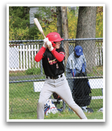 A baseball player in a red helmet and black shirt is holding a bat and getting ready to swing. Description generated by AI
