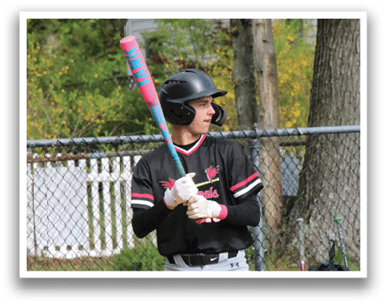 A baseball player is holding a bat and getting ready to hit a ball. Description generated by AI