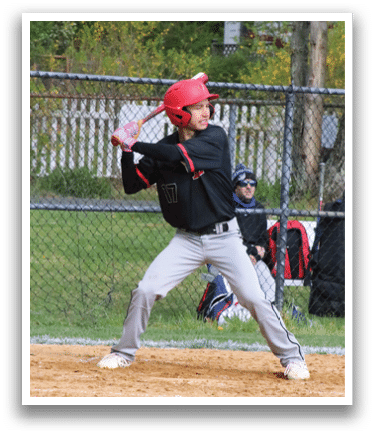 A baseball player in a black shirt and red hat is swinging a bat. Description generated by AI