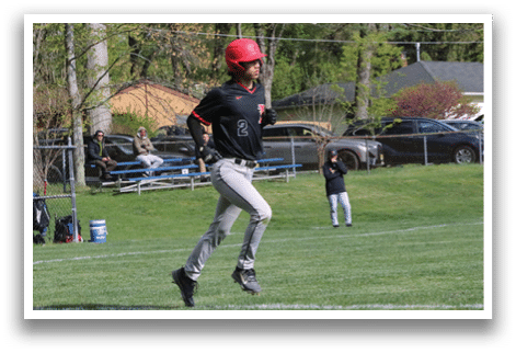A boy in a black and red baseball uniform is running on a field. Description generated by AI