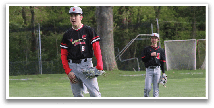 A baseball player wearing a black and red shirt and grey pants. Description generated by AI
