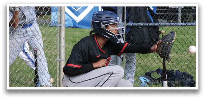 A baseball player is kneeling on the ground with a baseball bat. Description generated by AI
